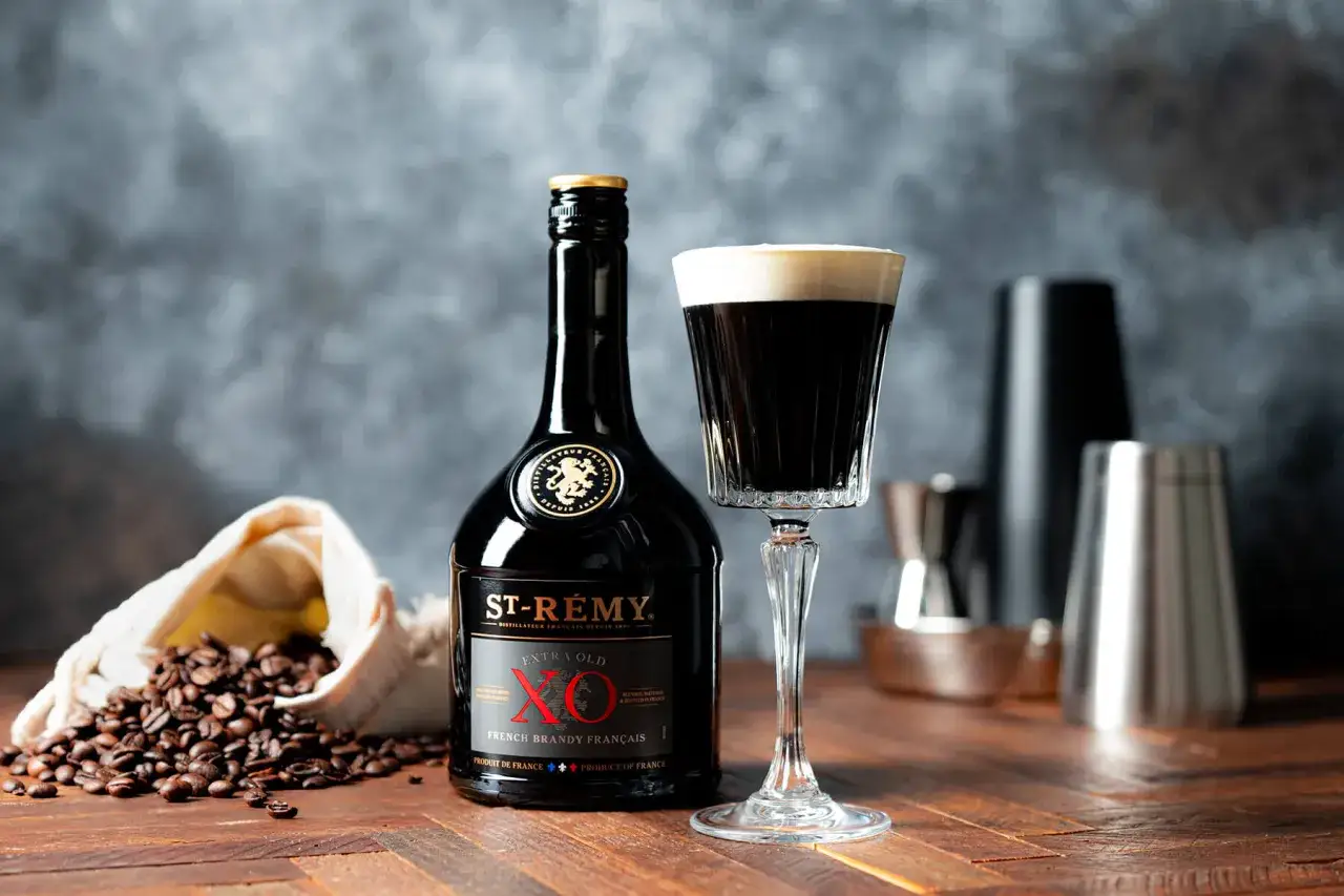En elegant drink med kaffe och konjak, bredvid en flaska St-Rémy XO och kaffebönor.