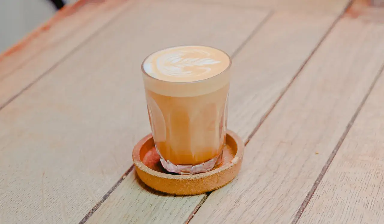 En vackert dekorerad kaffe latte på ett träbord.