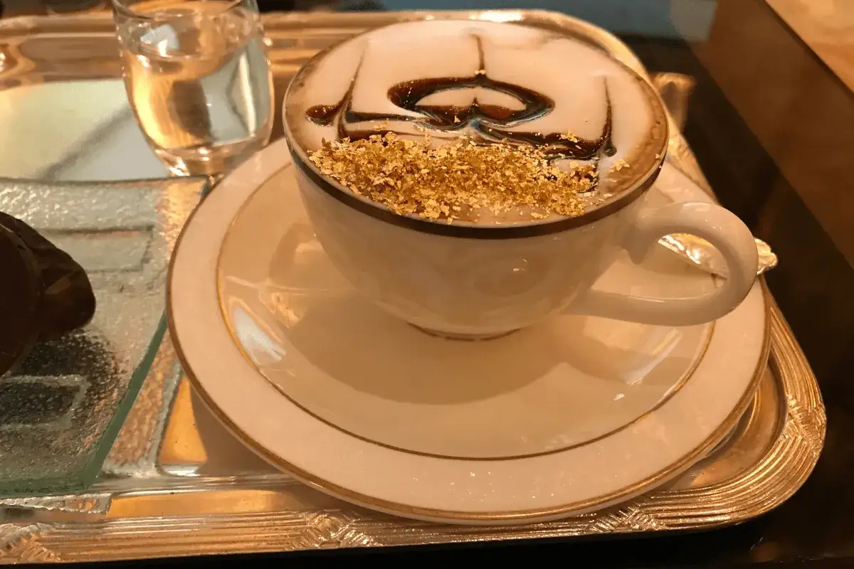 En lyxig kaffekopp med guldkant och chokladmönster, toppad med guldfolielöv. Detta är nog det dyraste kaffet jag sett!