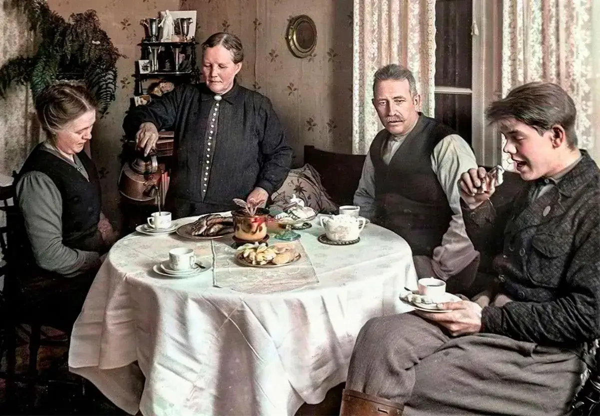 En familj samlas runt ett bord för att dricka kaffe. En kvinna häller upp kaffe ur en kopparbryggare, en annan kvinna och en man sitter och väntar. En ung man håller en kopp kaffe och en bit socker. Detta är en scen från kaffets historia.