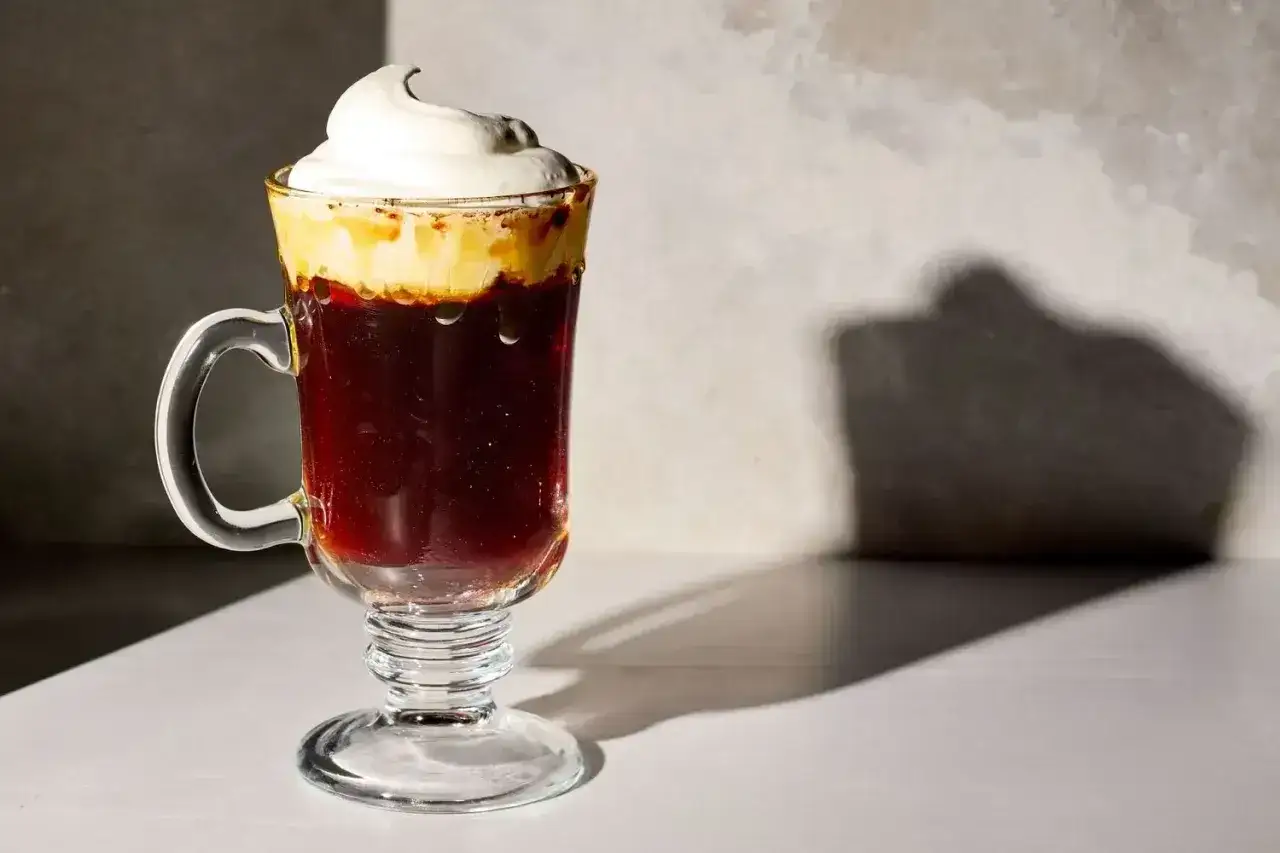 En lyxig Irish coffee med vispad grädde, en perfekt kombination av espresso och bryggkaffe.