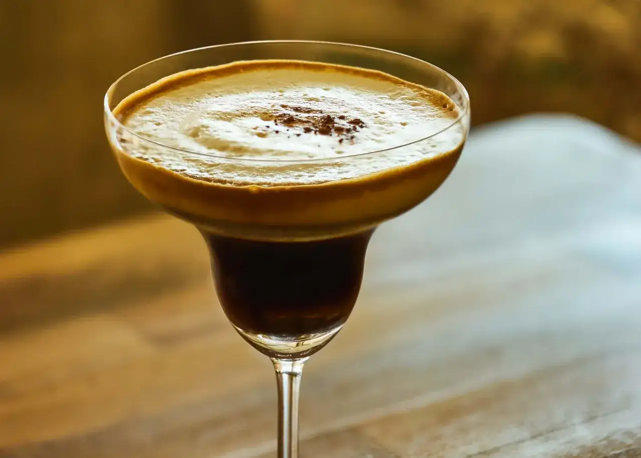 En lyxig kaffedrink med rom, toppad med krämigt skum och en nypa kakao. Perfekt för en mysig kväll.
